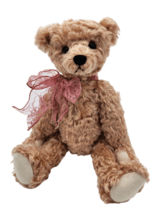 A teddy bear with a pink bow around its neck.