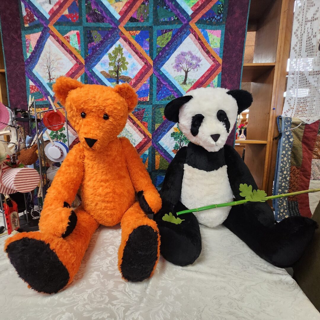 Orange bear and panda stuffed animals.